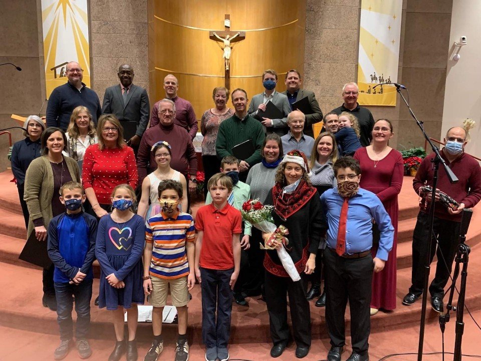Members of the Contemporary Group at Our Lady of Lourdes Church gather on the sanctuary steps in Our Lady of Lourdes Church in Columbia after performing a “Farewell to Christmas” concert. Free-will offerings from the event benefitted Catholic Charities Refugee Resettlement.
